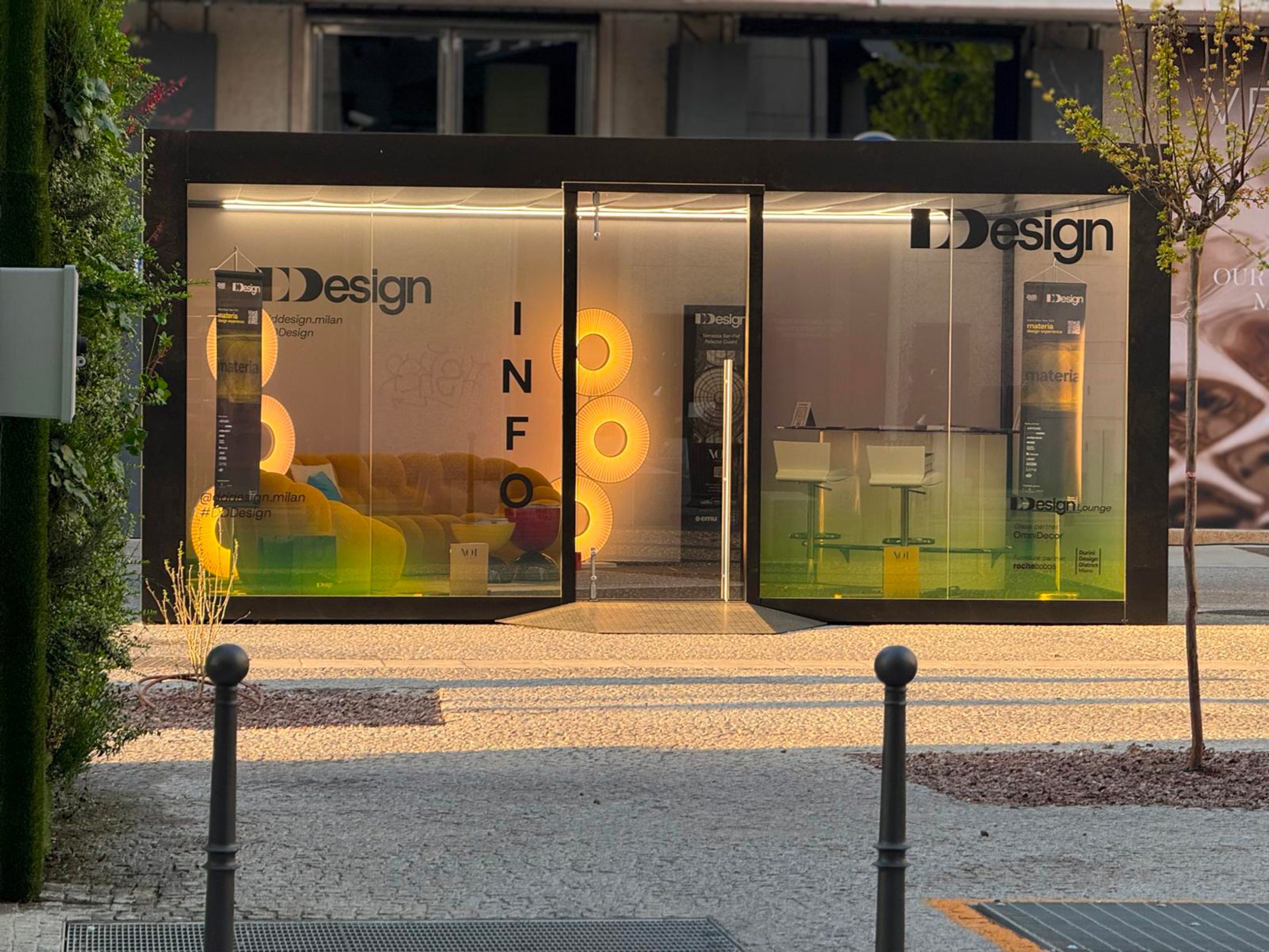 Vetrina negozio DDDesign Milano: divano giallo, sgabelli design, illuminazione circolare. Arredamento moderno e innovativo per interni ed esterni. Design made in Italy, esposizione DDDesign.
